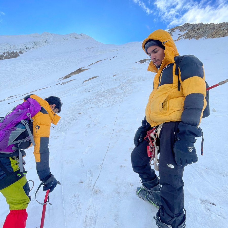 Two climbers on a glacier under a blue sky