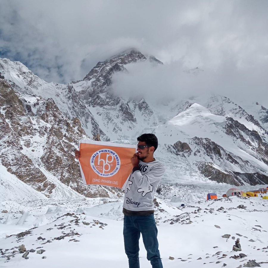 Fareed at K2 base camp with a sponsor flag