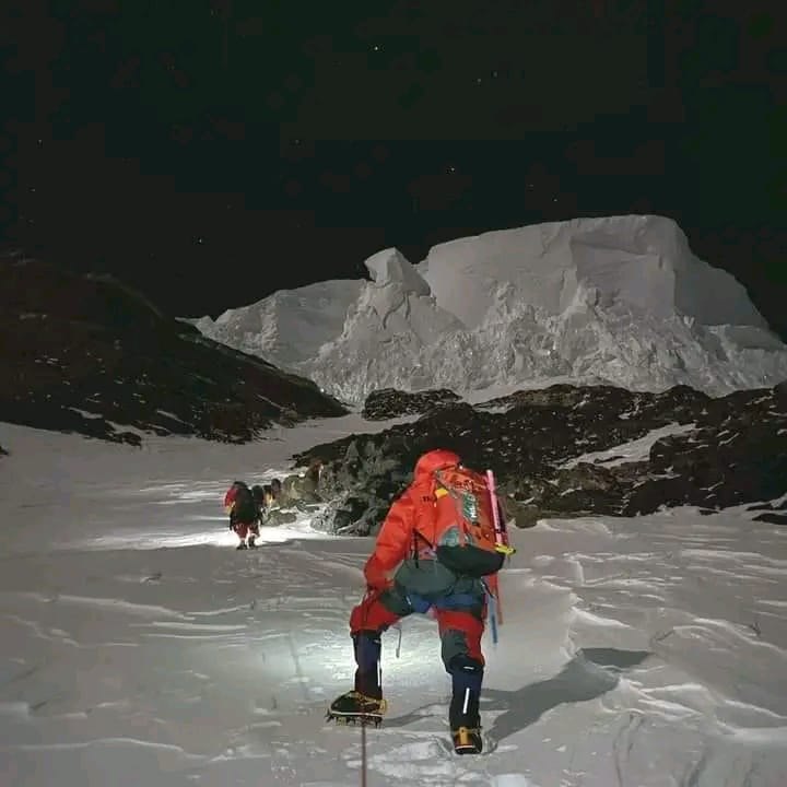 Climbing by headlamp in the dark toward a serac