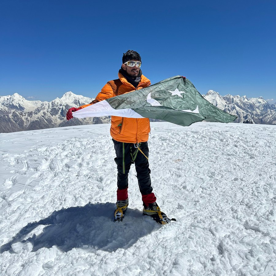 Standing on a snow summit holding the Pakistan flag
