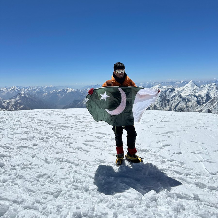 Fareed on a summit with the Pakistan flag